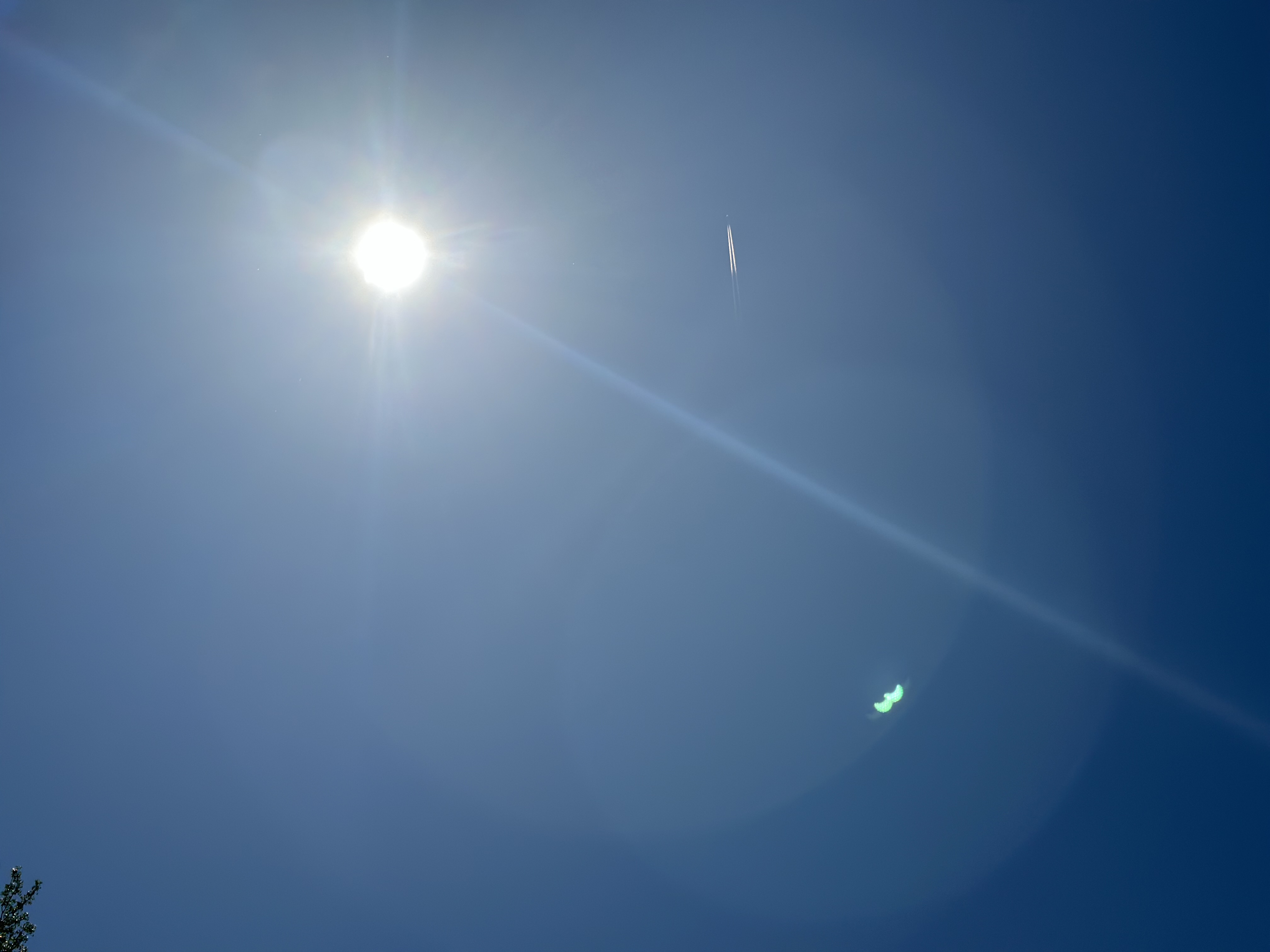 Lens flare in the shape of the eclipse with contrails